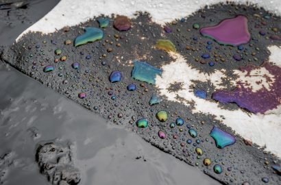 Oil spill on a worksite surface showing fuel contamination and environmental risk during field servicing operations