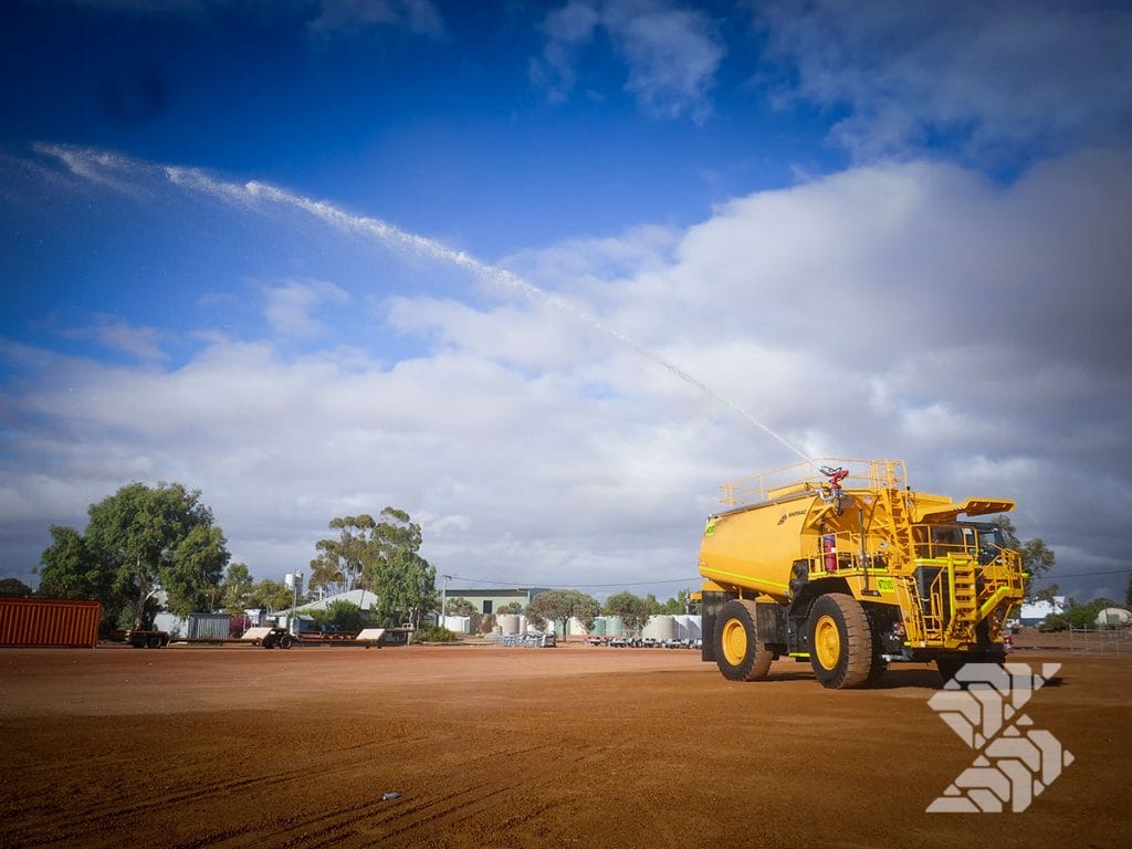  Heavy-duty mine-site water cart with high-pressure water cannon demonstrating spray reach and robust tank construction.