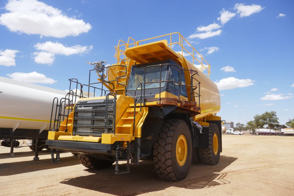 Face-on at ground level, a Shermac RS5000 off-road water cart towers over the red dirt WA yard