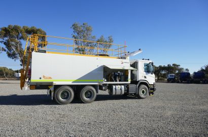 Shermac mine-spec service truck with safety railings, crane, and service body, parked on a gravel surface at an Australian mining operation