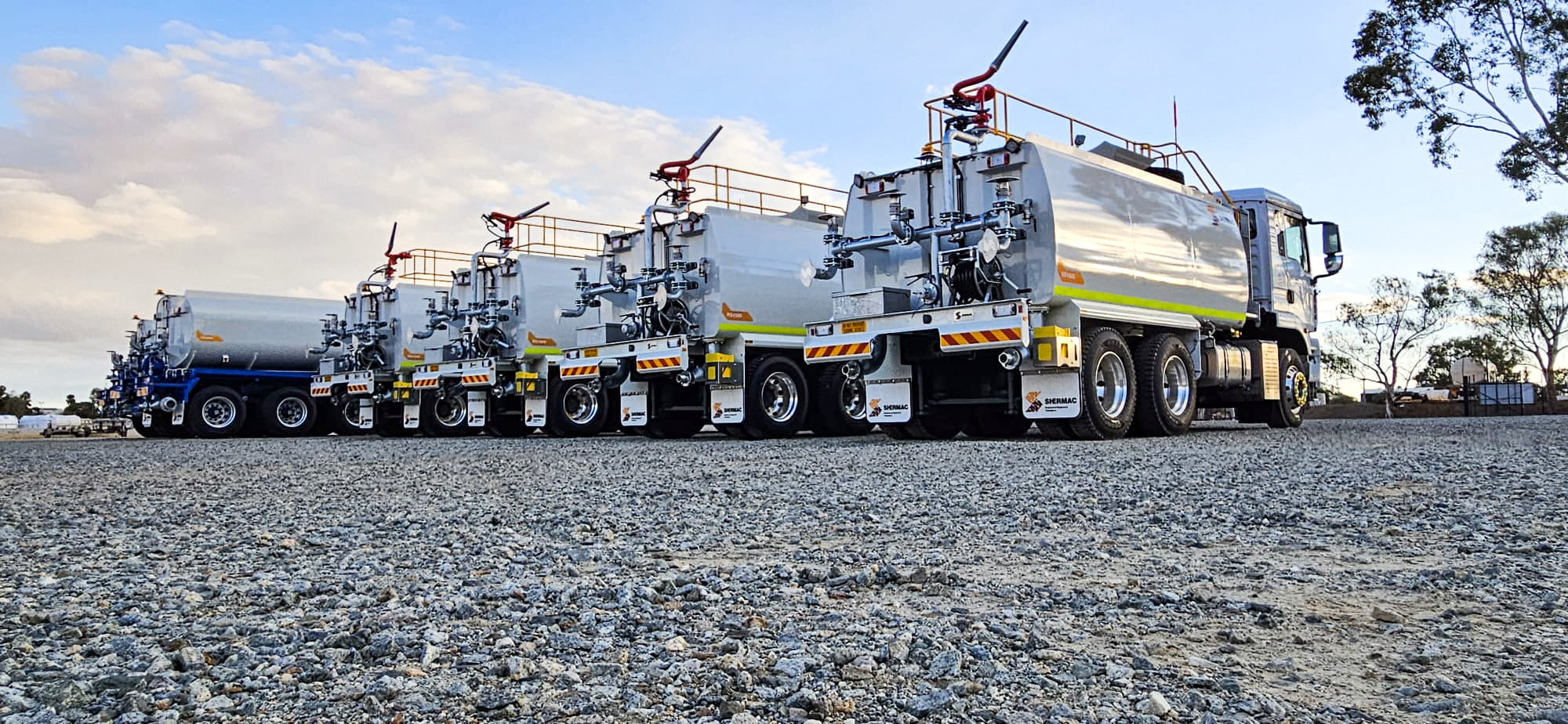 The Shermac water cart range in one shot, five stainless steel units on WA gravel hardstand
