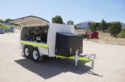 Shermac mine-spec service trailer with open service body, hose reels, fluid dispensing systems, and high-visibility markings, parked on a sandy surface at an Australian mining operation