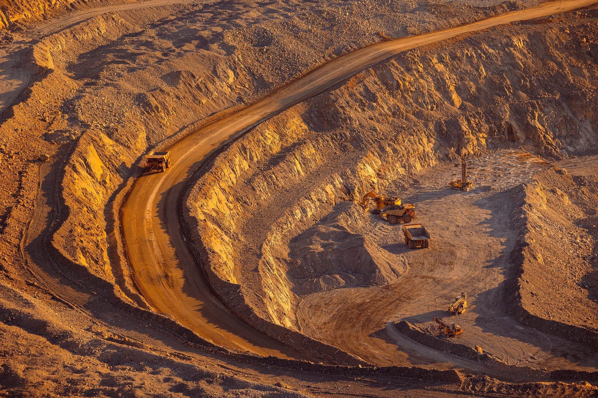 Heavy mining service trucks and excavator working in Australian mine site