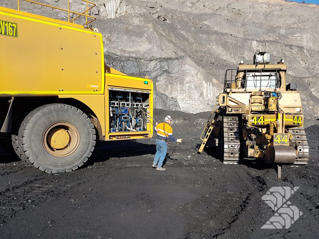 Shermac mine-spec service truck supporting field maintenance on a mining dozer at a remote heavy equipment job site.
