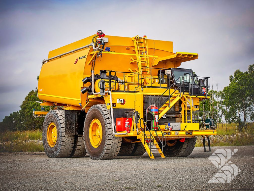 Rigid off-road water cart mounted on a CAT mining truck, showing high-capacity tank, access platforms and mine-spec safety features.